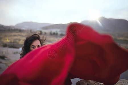 戏服吸引人的身穿红礼服黑发年轻女人在海滨附近岩石上跳舞纺织品图片