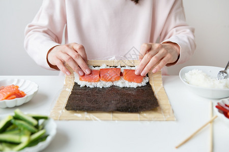准备寿司制作过程女孩不同口味的寿司新鲜三文鱼子酱鳄梨黄瓜姜米饭寿司制作过程女孩不同口味的寿司新鲜鲑鱼米饭费城一顿图片