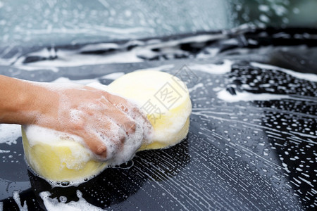 持有手黄色海绵和泡沫清洗窗的工人男子手持黄海绵和泡沫洗车用擦玻璃窗户人们气泡车站图片