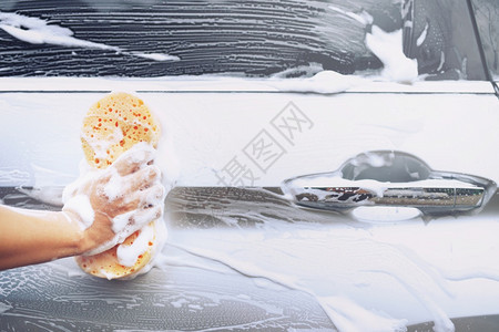 门肥皂运输持有手黄色海绵和泡沫清洗窗的工人男子手持黄海绵和泡沫洗车用擦玻璃窗户图片