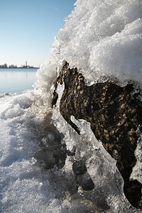 颜色低的在阳光明媚春日这一背景下紧贴冰雪无河和覆盖的岩石3月初的横向照片图拍摄到三月初欧罗巴图片