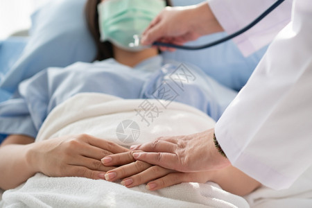 女医生握着病人的手鼓励和提供医疗咨询图片