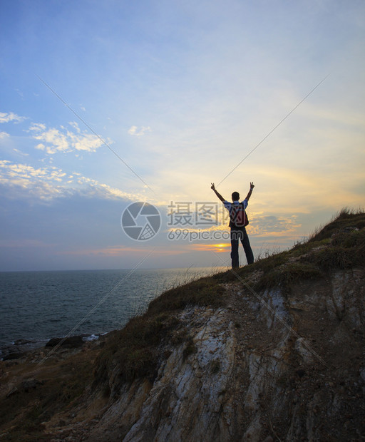 攀登年轻男子站在岩石悬崖上图片