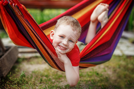 纺织品脚丫子美丽的快乐小男孩在吊床上休息玩得开心积极的情绪颜色图片