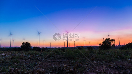 塔风力涡轮机养殖场景观美丽日落在暮光时黑幕下泰国NakornRachasima发电可持续时间图片
