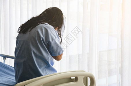 医疗的人们窗户躺在床上的亚裔女病人背影中她对自己的疾病表示悲伤并亲手面对健康保险概念图片