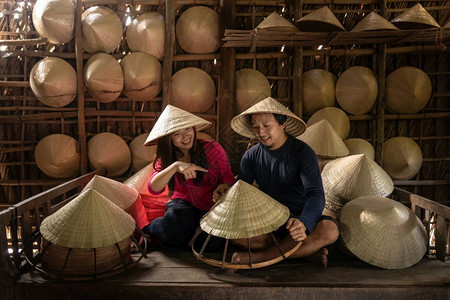 城市在越南霍希明ApThoiPhuoc村的旧传统房屋中亚洲夫妇旅行者手工艺匠在传统术家概念中制作传统维特南帽老的种族图片