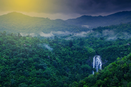 清晨雾中热带瀑布的风景对泰国日出KhlongLan公园热带雨林中的瀑布惊人空中观测长期点是瀑布山复制丛林图片