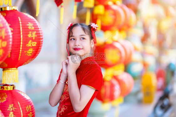 文化小可爱亚洲女孩穿着传统的青相红纸灯上面写着中文字母上帝保佑是财富祝福的赞美中华新年奖章幸运之福微笑庆典图片