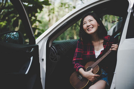 肖像夏天与白色汽车的Ukulele一起在户外暑假微笑和玩乐的亚洲美容女旅行摄影家Histster风格的概念和Solo女主题生活方图片