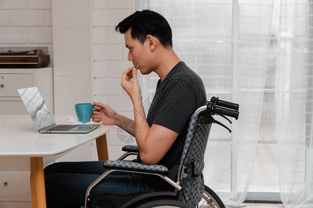 一名亚洲残疾男子坐在轮椅上的压力和失望是的在车祸发生后服用药品疏忽的概念和醉酒驾车的影响a失职在室内保险驾驶图片