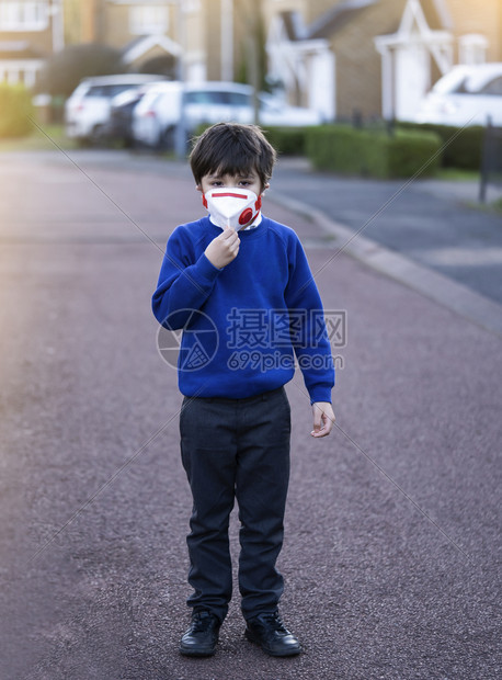 下午身戴防污染或护面罩的婴儿混血亚裔6岁幼童天主教徒步行上学时戴着保护面罩的儿童Corona或Coronava概念组织以及第25图片