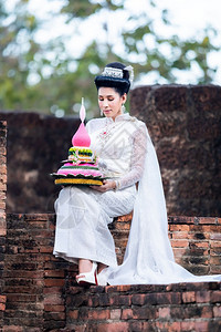 祷告身着泰国白色传统服装穿着Krathoong和坐在泰国古老城市塔寺门前的Trathong妇女LoyKrathong节Trans图片