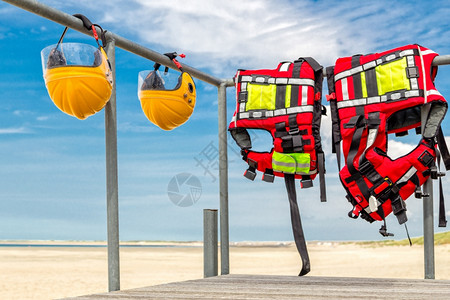 海滩护栏上挂着安全头盔和救生衣图片