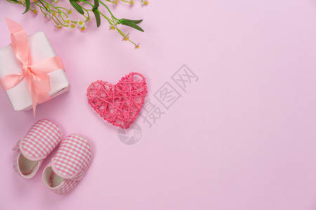 欢乐母亲节假日背景概念Flat便衣礼物盒配有婴儿鞋和爱花装饰的鲜贴在现代美丽的粉红纸上家用办公桌台复印空间展示孩子们概念平图片