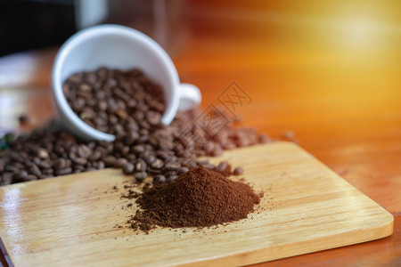 漂亮白咖啡杯和豆放在木制桌上精心安排配有咖啡叶装饰品是咖啡原料的混合材之一煮咖啡倾倒香气图片