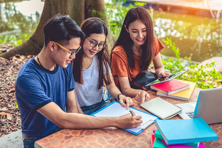 青年学生们一起在公园石桌上学习图片