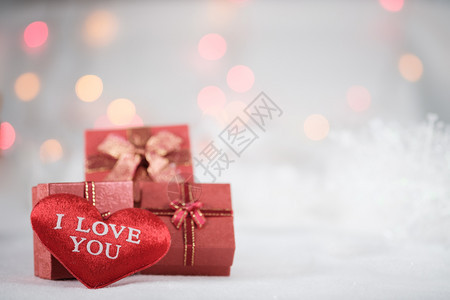 为了裹红礼盒和心在bokeh背景的白皮上穿色毛衣有快乐或新年节季喜悦或新年点选择的复制空间装饰风格图片