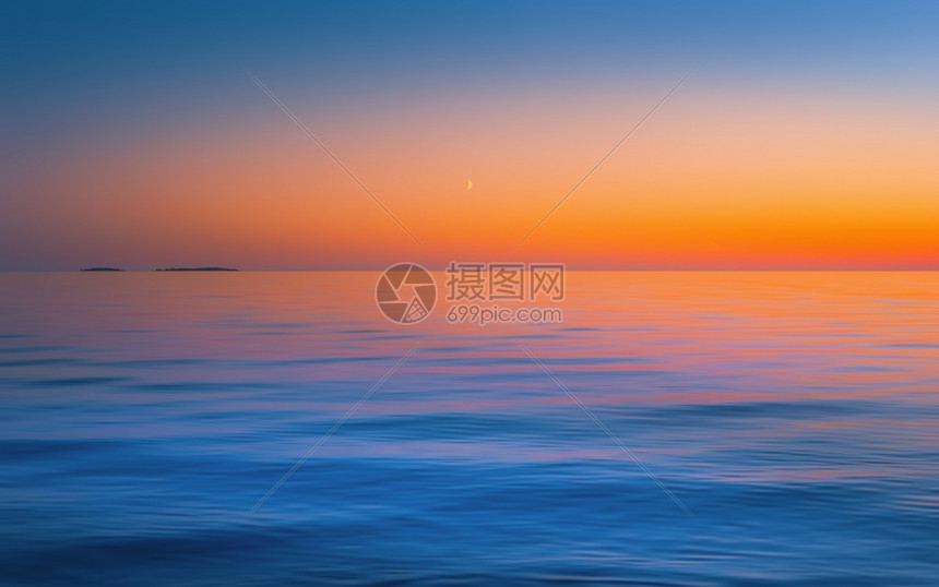 卡累利阿美丽的无风红黄日落后在清空中的新月亮反映在流水表面中抽象运动以橙色蓝和复制空间俄罗斯Onega湖的紫色颜模糊了海景背图片