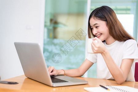 航运亚洲女在办公室商业营销和兼职概念中使用笔记本电脑和互联网时享受生活在网上购物和商业成功主题上愉快地做工作乐的心情桌子时间图片