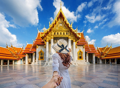 建筑学观光妇女旅游者手牵着rrrrsquos手将他带到泰国曼谷的WatBetchamabophipit或Marble寺庙裙子图片