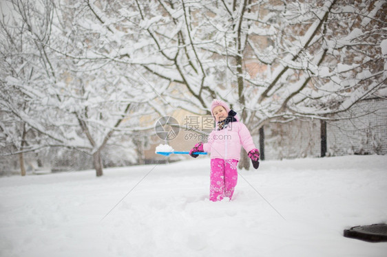 下雪的有趣戏剧孩子在冬天玩雪一个穿着亮色夹克和针织帽的小女孩在冬季公园里为圣诞节捕捉雪花孩子们在白雪覆盖的花园里玩耍和跳跃孩子在图片