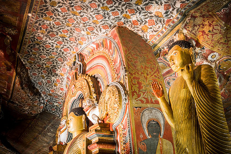 游客古老的异国情调许多佛像的惊人景象和在斯里兰卡圣金寺丹宝拉洞穴内雕刻的宗教在斯里兰卡旅行目的地图片
