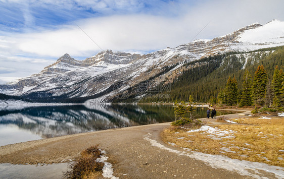 游客在加拿大艾伯塔邦夫公园的冰地道上山面反落基脉射横湖大冬季风景加拿大艾伯塔省班夫公园湖岸曲线图片