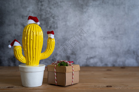 球欢乐新年的装饰品概念化Cactus锅和红色礼品盒用于现代棕褐黄红宝石背景空间设计晚宴季节的红礼盒物件木头结石图片