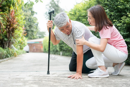 女士搀扶摔倒的老年人图片