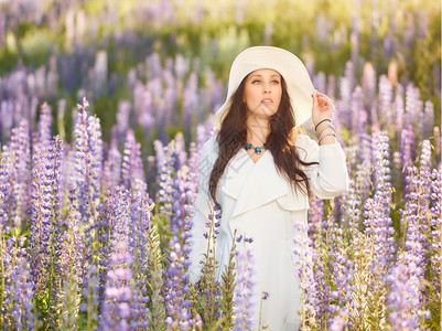 白种人柔软的放松穿着白色帽子和外套夏日草原的时装年轻女子图片