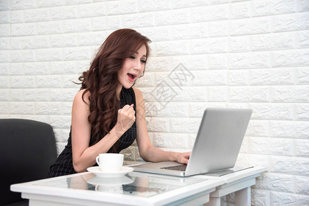 营销支付亚洲妇女在成功获得新启动项目或与笔记本电脑商业和成功者概念购物和推广概念技术和互联网通信主题在线投标后快乐亚洲妇女在成功图片
