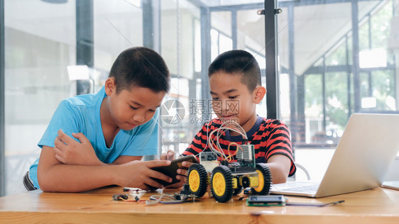 在室内学校手制汽车模型工作电子集中男孩在实验室制造机器人的建筑工程早期开发暗展创新现代技术概念和新颖作坊图片