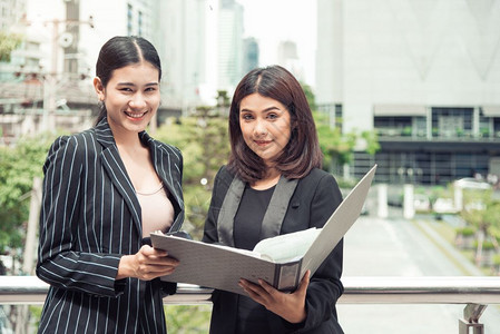 两名年轻的亚洲女企业家他们研究文件档案夹以分析在推销之后的利润或售突破点然后分析利润或销售中断点商业团队合作雇员与工妇女的生活方图片