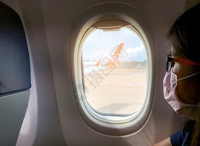 商业旅游成人生病妇女佩戴面罩在机场新科罗纳2019nCoV感染或Wuhancorona起飞机上客乘坐的舱窗户附近座经济上戴面罩图片