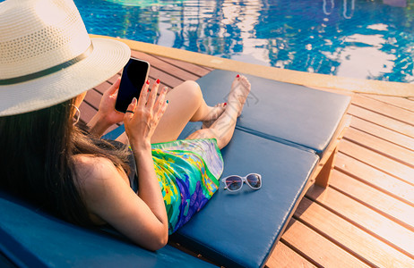 女人泳池度假看手机图片