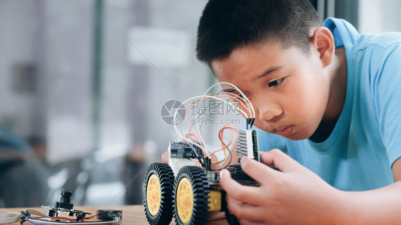 课堂手制汽车模型工作电子集中男孩在实验室制造机器人的建筑工程早期开发暗展创新现代技术概念和新颖在室内能图片