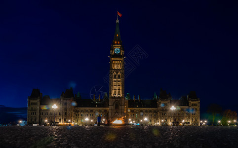 晚上议会建筑物旗帜灯加拿大国会厦和加拿渥太华百年火烈夜照加拿大议会楼和加拿渥太华低角度背景