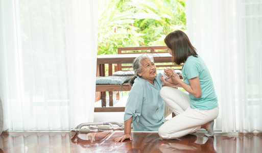 脆弱的老防止亚洲高龄妇女在家里躺地上摔倒之后亚洲高龄妇女在门口被打倒痛苦地哭泣护士来帮助支持老年保险和健的概念图片