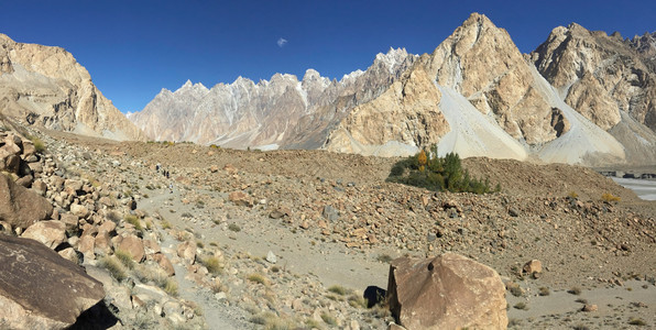 巴基斯坦GilgitBaltistan沿线的卡拉科姆山脉草地和食用植物等雪盖山坡巴基斯坦吉尔特Baltistan徒步旅行者沿着蓝图片