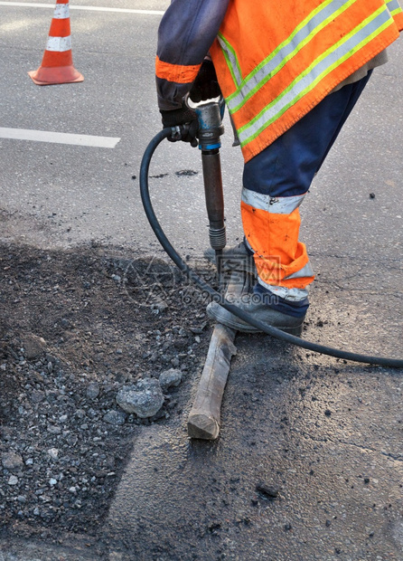 A路工在修复公时用1个大锤擦干一些沥青同时修理道路垂直图象复制空间A路工在修复公时用1个大锤清除了部分沥青校对Portnoy出去图片