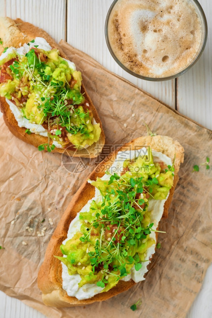 吐司最佳配奶油酪微绿和芝麻种子的Avocado三明治加奶油酪微绿色和芝麻种子印在纸衬上面传播图片