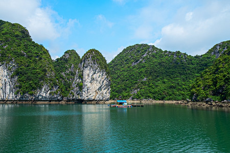 越南HalongBay东南亚的房屋和岩石岛教科文组织东南亚世界遗产地位于越南HaLongBay最受欢迎的地标越南漂浮屋旅游景点岩图片