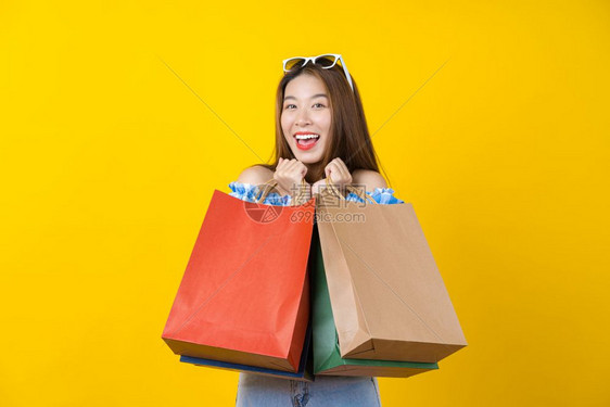 消费者带着孤立的黄色背景复制空间和工作室黑色星期五季节销售概念的购物合着包袋在黑周五销售中进行购物淑女图片