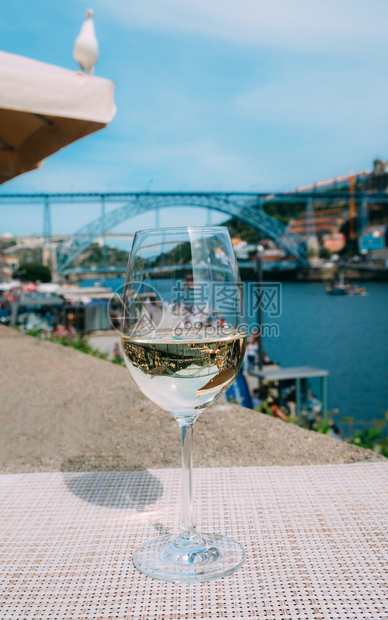 罗滕贝格葡萄牙波尔图杜罗河上俯瞰CaisdaRibeira和PontedeDomLuisI的白葡萄酒杯选择焦点玻璃上桥的反射白葡图片