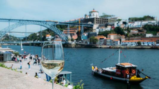 吸引力葡萄牙波尔图杜罗河上俯瞰CaisdaRibeira和PontedeDomLuisI的白葡萄酒杯选择焦点玻璃上桥的反射白葡萄图片