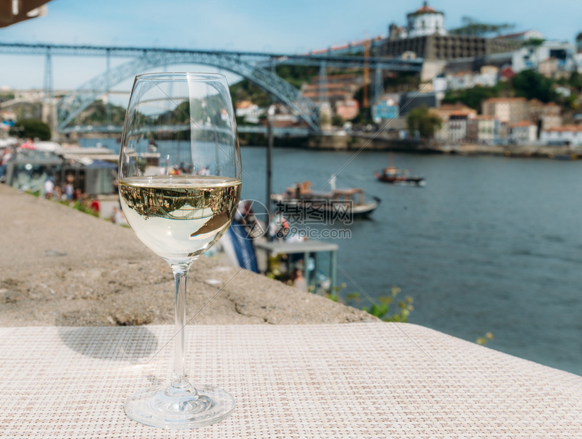城市船边缘葡萄牙波尔图杜罗河上俯瞰CaisdaRibeira和PontedeDomLuisI的白葡萄酒杯选择焦点玻璃上桥的反射白图片