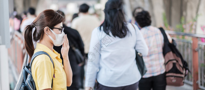 在公共场所佩戴口罩的青年女性图片