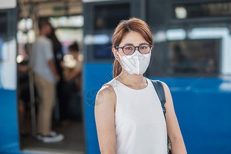 年轻女性在公共火车站戴防护口罩图片