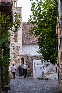 地中海人们在塞浦路斯Troodos山的老Kakoopetria小街道上漫步女孩走在远处户外家图片